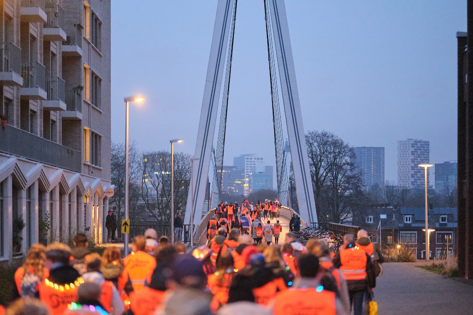 Mensen tijdens de zonopkomst aan het lopen over een brug
