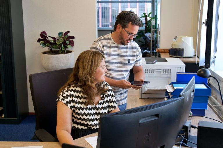 Kantoor foto met vrouw en man achter een computer
